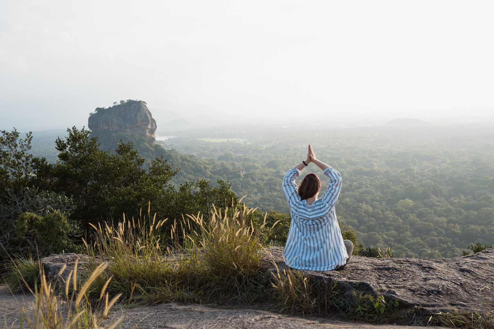 Woman doing yoga at sunset with scenic view Sigiriya in Sri Lanka